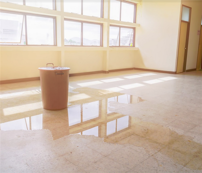 water leaking into an overflowing bucket in an office building